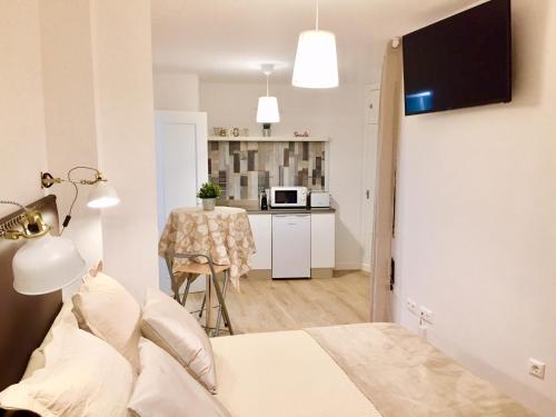 Cet appartement comprend une chambre avec un lit et une cuisine avec une table. dans l'établissement Centro Malaga, à Malaga