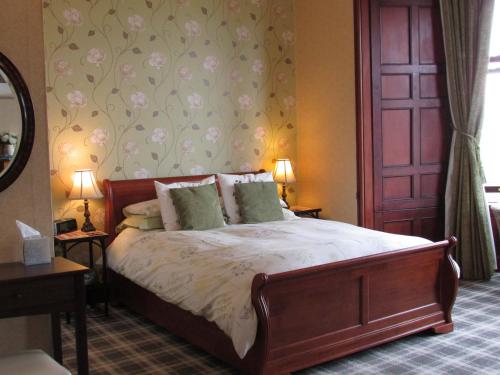 a bedroom with a bed and a dresser at Hillcrest House in Wigtown