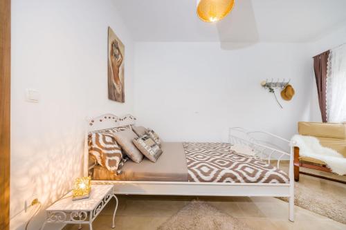 a white bed in a white room with a couch at Little Dream in Poljana