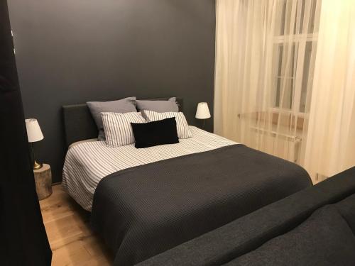 a bedroom with a bed with a black and white comforter at Kuninga Apartment in Tallinn