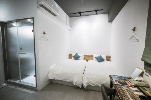 a bedroom with a bed and a glass shower at Tiin Tinn - Rivershore B&B in Taitung City