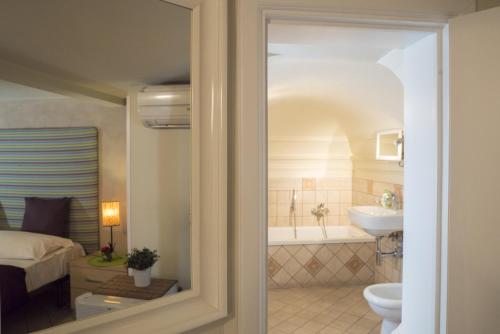 a bathroom with a tub and a toilet and a sink at RossoCorallo B&B in Catania