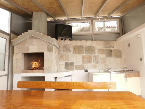 a stone fireplace in a kitchen with a bench at Villa Valenta-Klis near Split, heated pool & view in Klis