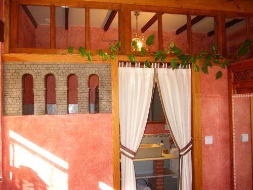 a room with a window with curtains on it at Hotel Rural La Rosa de los Tiempos in Carneros