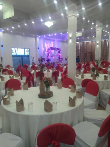 a banquet hall with white tables and red chairs at Green Shadows Beach Hotel in Kalutara