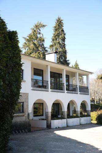 a large white building with a balcony at Casa dos Arcos in Caramulo