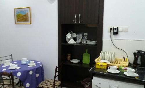 a kitchen with a table with a blue table cloth at Hostel City Center in Kutaisi