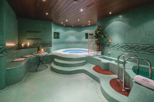 uma casa de banho com uma banheira e uma cabina de duche ao nível do chão em Franceschi Park Hotel em Cortina dʼAmpezzo