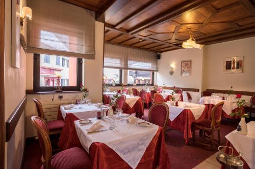 a dining room with tables with red and white tablecloths at Logis Hostellerie Motel Au Bois Le Sire in Orbey