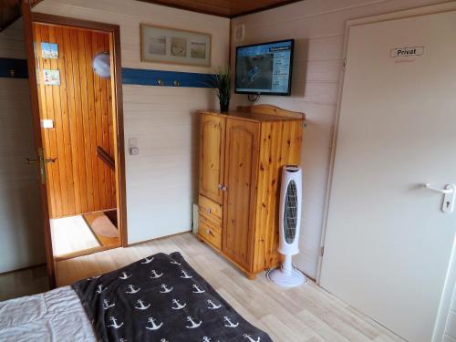 a bedroom with a bed and a tv on a wall at Ferienhäuser Seemannsgarn in Friedrichskoog-Spitz