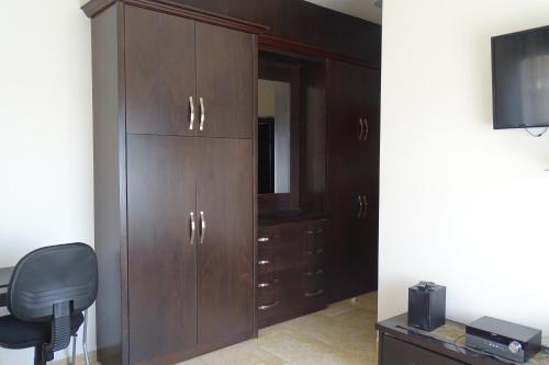 a bedroom with wooden cabinets and a chair and a television at Sage &Thyme in Nazareth