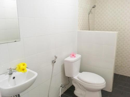 a white bathroom with a toilet and a sink at Indekost Bogor in Bogor