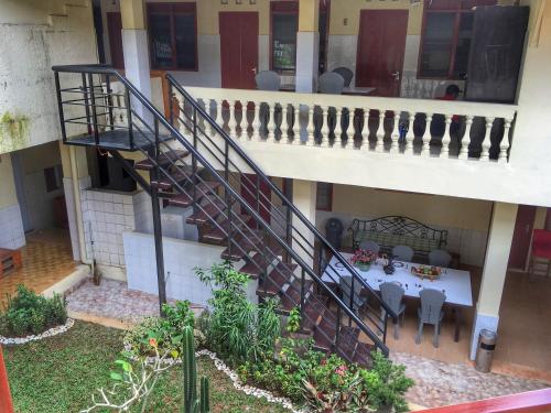 a spiral staircase in a building with a table and chairs at Indekost Bogor in Bogor