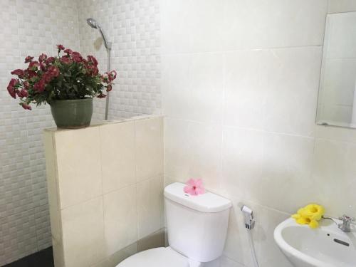 a bathroom with a toilet and a sink and a plant at Indekost Bogor in Bogor