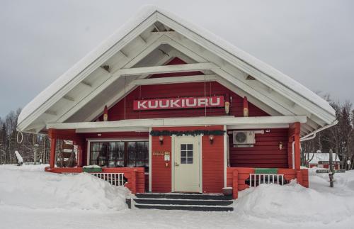 a red building with a kushknife sign on it at Holiday Village Kuukiuru in Vuostimo