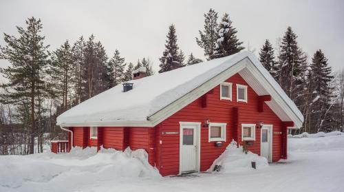 a red house with snow on top of it at Holiday Village Kuukiuru in Vuostimo