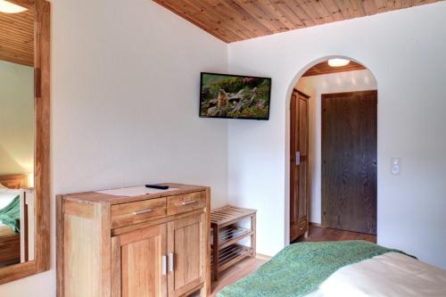 a bedroom with a bed and a tv on the wall at derNeuwirt in Schwendau