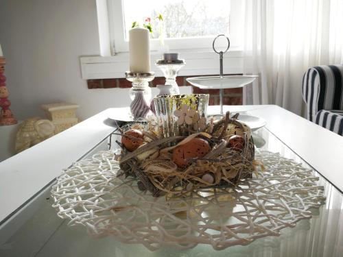 a wicker basket on a table with a candle on it at Gartenblick in Zingst