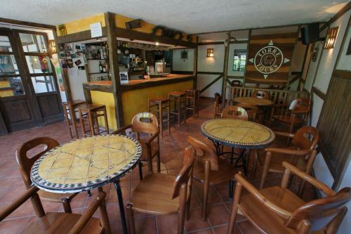 a restaurant with two tables and chairs and a bar at Hotel Torrecerredo in Arenas de Cabrales