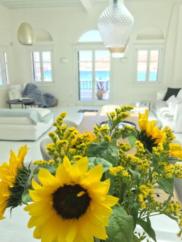 a vase of sunflowers on a table in a living room at Pnoe in Mýkonos City