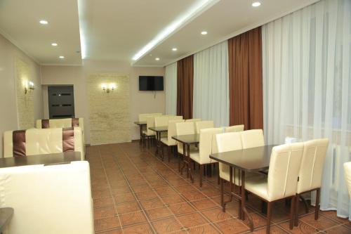 a conference room with white chairs and a table at Aska Hotel in Naryn
