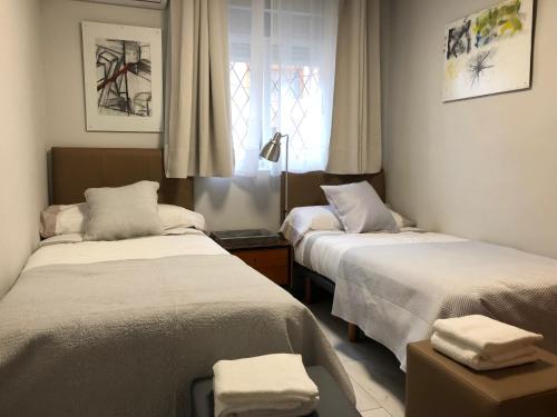 a bedroom with two beds and a window at Casa del Vado in Toledo