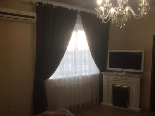 a room with a window with a television and a chandelier at Hotel Grant in Kharkiv