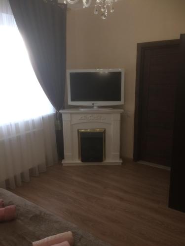 a living room with a tv and a fireplace at Hotel Grant in Kharkiv
