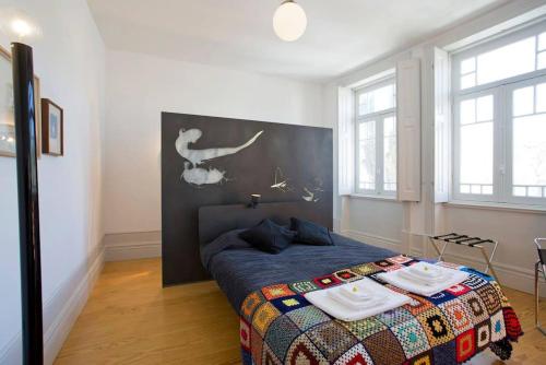 a bedroom with a bed in a room with windows at 14º Esquadra — Cais das Pedras Guest House in Porto