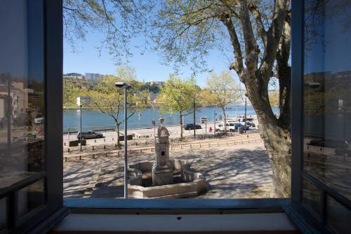 a window with a view of a park and a body of water at 14º Esquadra — Cais das Pedras Guest House in Porto