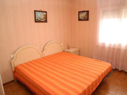 ロザスにあるMARENOSTRUM 2 4º4ªのベッドルーム1室(オレンジ色の毛布付きのベッド1台付)