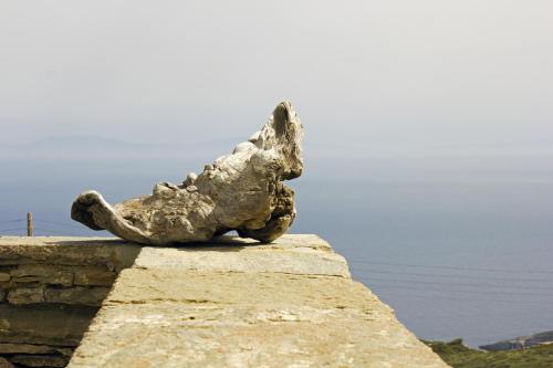 a statue of a rabbit laying on a wall at Bioclimatic stone built villa in Kastrianí
