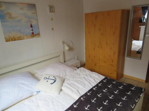 a bedroom with a white bed with a red lighthouse at Ferienhäuser Seemannsgarn in Friedrichskoog-Spitz