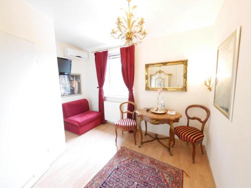 a living room with a table and chairs and a red couch at Hotel Rotdorn in Berlin