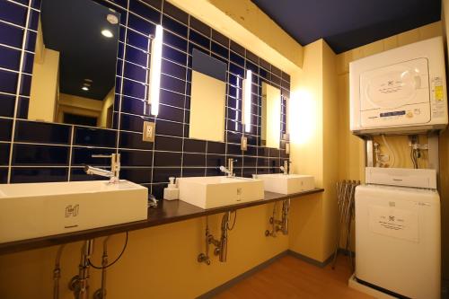 岡山市にあるヒバリ ハウスの洗面台3つと鏡付きのバスルーム