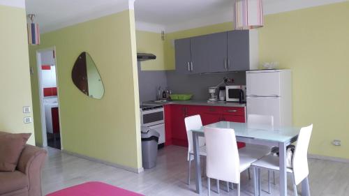 La cuisine est équipée d'une table, de chaises et d'un réfrigérateur blanc. dans l'établissement Studio couleur gai, à Amélie-les-Bains-Palalda