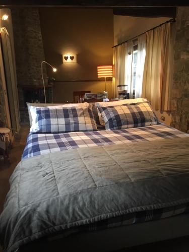 uma cama grande com cobertores e almofadas azuis e brancos em River Idyll em Bagni di Lucca