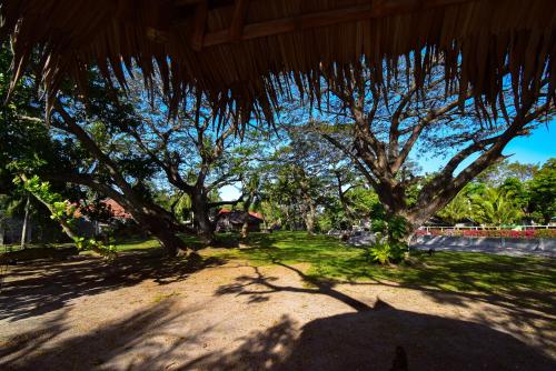 a shadow of a person under a straw umbrella at Greenland Residence House in Zamboanguita