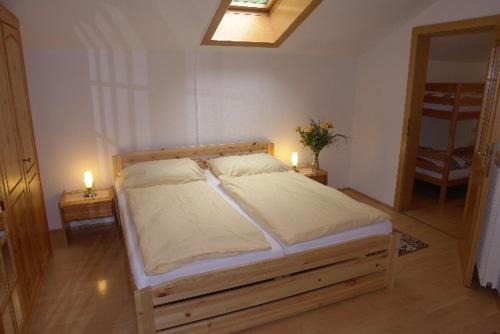 Fischgasthof Aumüller في Obermühl: غرفة نوم بسرير مع وجود شمعتين على طاولتين