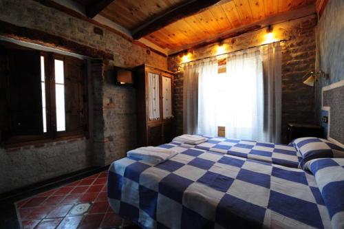 a bedroom with a blue and white checkered bed at Hotel Rural La Enhorcadora in Portillo