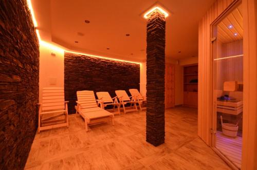 a room with white chairs and a brick wall at Hotel Resort Martin & Kristyna in Špindlerův Mlýn