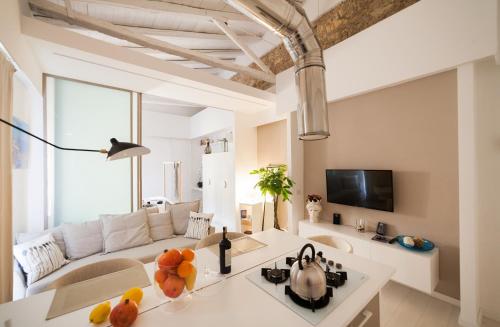 a living room with a white couch and a table at Stay In Ortigia in Siracusa