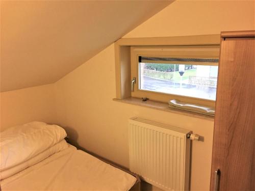 Una pequeña habitación con una cama y una ventana. en Huisje Zeegenoegen Oostduinkerke Koksijde, en Oostduinkerke