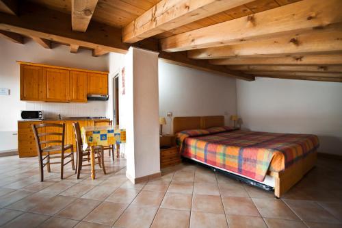 a bedroom with a bed and a table and chairs at Agritur Le Sigalette in Salionze