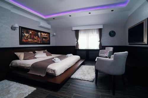 a bedroom with a large bed and a chair at Lux apartmani Beograd in Belgrade