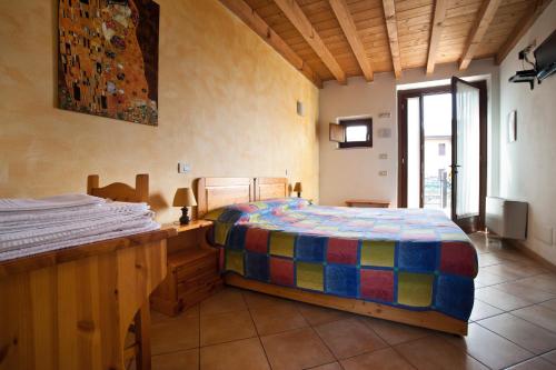a bedroom with a bed with a colorful comforter at Agriturismo Le Sigalette in Salionze