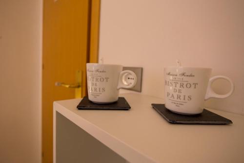 two coffee cups sitting on top of a counter at Albergo Felice in Sottomarina