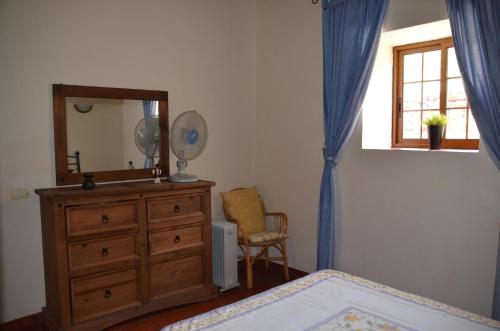 a bedroom with a dresser and a mirror and a chair at Rural Gomera in Arure