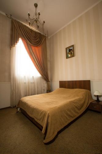 a bedroom with a large bed and a window at Magnat Lux Hotel in Chernivtsi