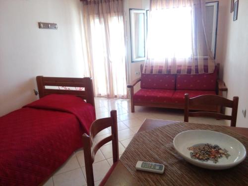 a living room with a bed and a table with a plate on it at Delfini in Akhladherí